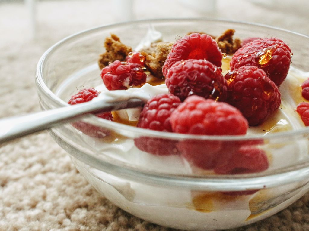 Bowl of thick creamy homemade Greek yogurt from the slow cooker, topped with fresh berries and granola
